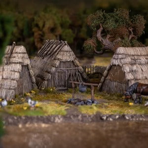 Miniatuur Dark Age Huts van Victrix, gedetailleerde gebouwen voor historische scenes, zichtbaar in de afbeelding.